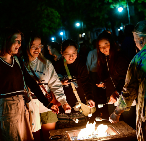 Students roasting smores over a fire